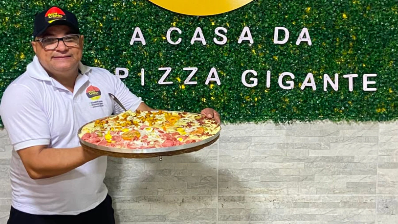 Proprietário do Point Cristão exibindo a Pizza Golias