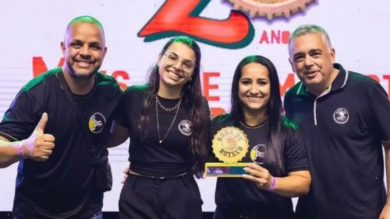 Equipe do Dona Dalva Botequim comemorando com o troféu Roda de Boteco no palco